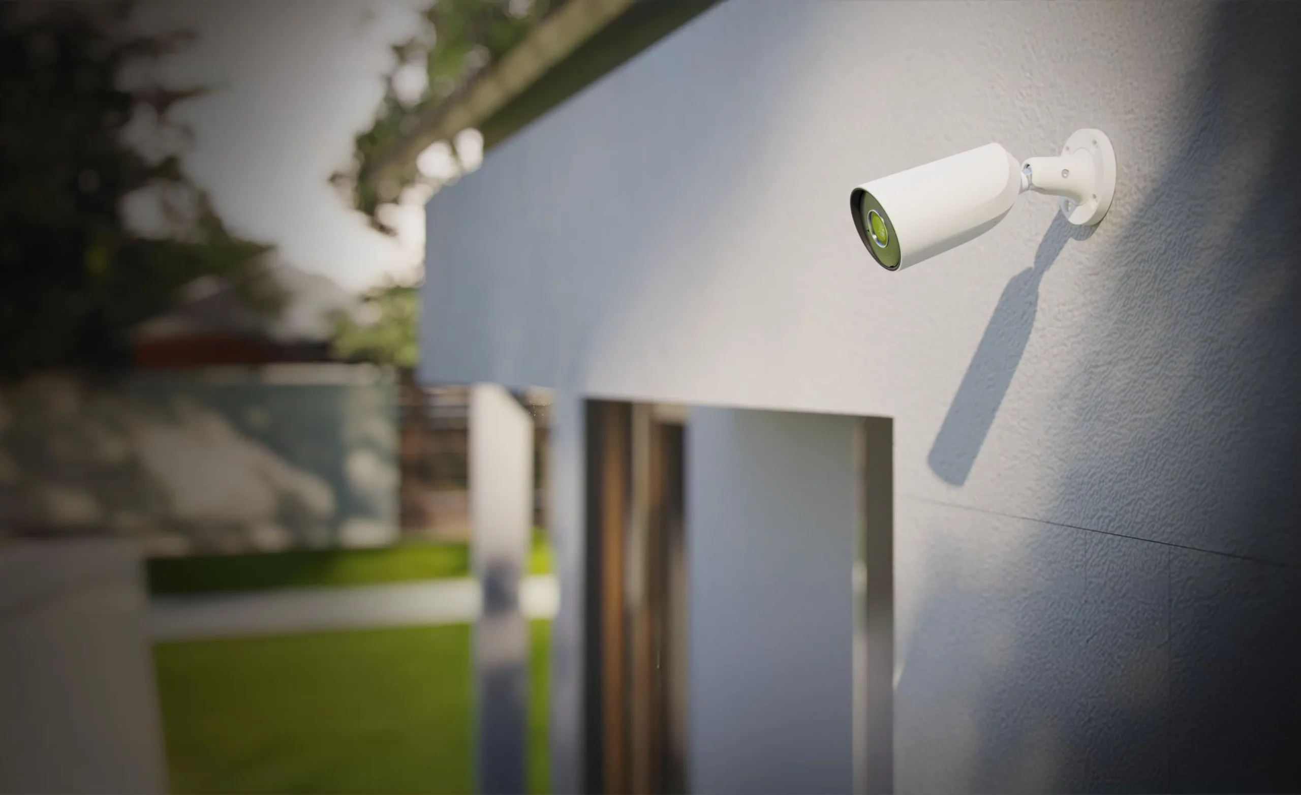 Caméra de vidéosurveillance extérieure installée sur une façade, assurant la sécurité d’une habitation avec jardin.