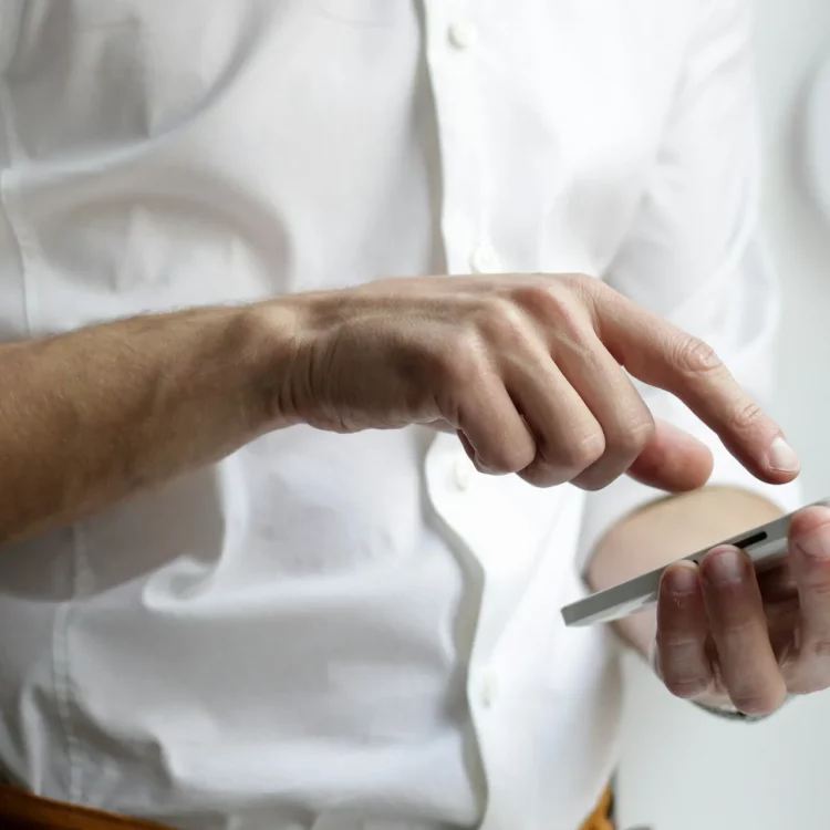Personne utilisant un smartphone pour gérer un système de sécurité connecté.